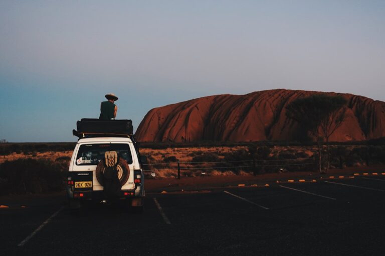 Brewing Coffee from a Hand-Grinder While Watching the Sunrise Over Uluru in a Campervan